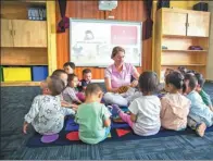  ?? PROVIDED TO CHINA DAILY ?? Toddlers sit around and listen to a foreign teacher at JD.com’s free kindergart­en for staff children.