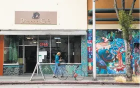  ??  ?? Dimond Cafe and a colorful mural are seen along Fruitvale Avenue in the heart of the Dimond District's shopping area.