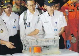  ??  ?? An Indonesian transport safety committee team carries a box Thursday containing a flight recorder from the Lion Air jet that crashed into the sea early Monday.