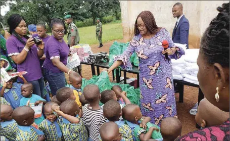  ??  ?? Wife of Enugu State Governor, Mrs. Monica Ugwuanyi (right), distributi­ng school materials to indigent pupils of St. Vincent Nursery and Primary Schools, Amaigbo Ozalla in Nkanu West Local Government Area of Enugu State.. yesterday.