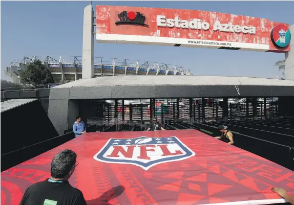  ?? — AP PHOTO ?? Workers prepare a billboard for Sunday’s NFL game between the Patriots and Raiders in the thin air of Mexico City.