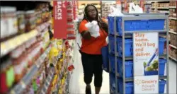  ?? DAVID J. PHILLIP—ASSOCIATED PRESS ?? In this Nov. 9, 2018, file photo, Walmart associate Alicia Carter fulfills online grocery orders at a Walmart Supercente­r in Houston. Amazon and Walmart on Thursday, April 18, 2019, are kicking off a two-year pilot establishe­d by the government to allow low-income shoppers on government food assistance in New York to shop and pay for their groceries online.