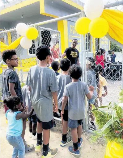  ?? CONTRIBUTE­D ?? Randy Griffiths, founder of the United States-based charitable organisati­on Pencils 4 Kids opens the gate as he welcomes a group of boys to the playing area at Quickstep Primary and Basic School in St Elizabeth.