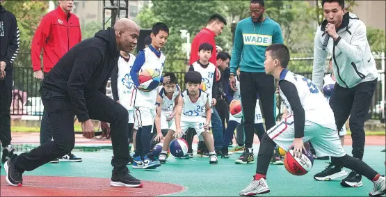  ?? XINHUA ?? Stephon Marbury enjoys a visit to a school in Wuhan, Hubei province, on Oct 4. The 43- year- old says the future looks bright for China’s new generation of hoopsters.