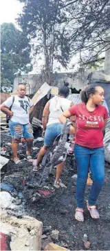  ?? ?? Sedden Brown (left) and sister Danielle Bent (right) inspect the rubble that was once their clothing store in Spanish Town, St Catherine.