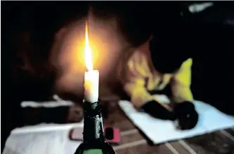  ?? AYANDA NDAMANE African News Agency (ANA) ?? A YOUNG boy does his homework by candle light as load shedding persists. |