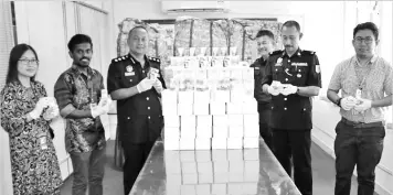  ??  ?? Pajeri (third le ) with boxes of unregister­ed Chinese traditiona­l medicine that were seized.