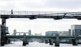  ?? AP ?? A pedestrian walks across the Millennium Bridge over the River Thames in London on May 11, during the morning rush hour as the lockdown continues to help stop the spread of coronaviru­s.