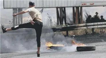  ??  ?? 0 A Palestinia­n protester hurls rocks amid confrontat­ions with Israeli security forces