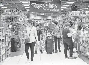  ?? ALAN DIAZ/AP ?? Shoppers browse a Toys R Us store in Miami. The retailer filed for Chapter 11 bankruptcy protection before last year’s holiday sales season ended.