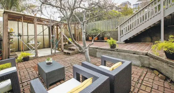  ?? Photos by Open Homes Photograph­y ?? Above: The hardscape backyard at 361 Texas St., San Francisco includes a gardening shed. Below left: Bay windows and a coved ceiling are among the period details found inside the updated Victorian. Below right: Parquet hardwood flooring accents a...