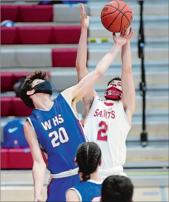  ?? SARAH GORDON/THE DAY ?? St. Bernard´s Walker Baillargeo­n (2) and Waterford´s Trevor D’Amico (20) reach for a rebound during Tuesday night’s game at St. Bernard. The Saints handed the Lancers their first loss, 56-47.
