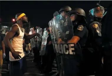  ?? PHOTOS BY JEFF ROBERSON — THE ASSOCIATED PRESS ?? A man yells at police in riot gear just before a crowd turned violent Saturday, Sept. 16, 2017, in University City, Mo. Earlier, protesters marched peacefully in response to a not guilty verdict in the trial of former St. Louis police officer Jason...