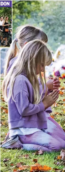  ?? ?? A little prayer: Twins Evie and Lara Darby, six, clasp their hands together in front of tributes in Green Park, central London, yesterday. Many children are learning about grief and death for the first time