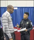  ?? STEVE SCHAEFER / SPECIAL TO AJC ?? U.S. Customs recruiter Megan Mason works the Airport Community Job Fair on March 30.