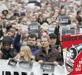  ?? Ansa ?? Tutto è perdonato Il corteo subito dopo la strage e due copertine celebri del settimanal­e satirico