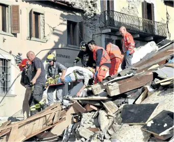  ?? GETTY IMAGES ?? Rescuers carry a man on a stretcher among damaged buildings after a strong earthquake hit central Italy, in Amatrice on Wednesday. A powerful 6.2-magnitude earthquake devastated mountain villages in central Italy on Wednesday, leaving at least 18...