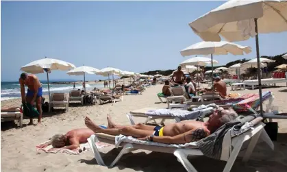  ?? Photograph: M Sobreira/Alamy ?? Sunbathing on Es Cavallet beach, Ibiza. Cancer Research says: ‘It’s important to take care in the sun.’