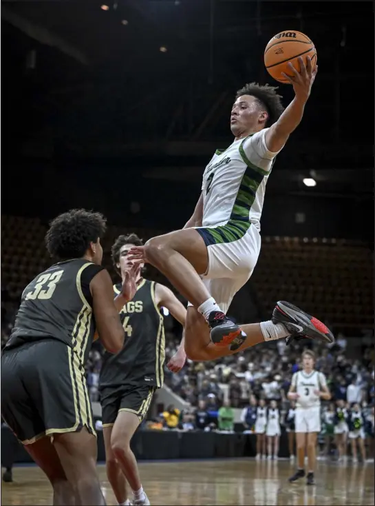  ?? AARON ONTIVEROZ — THE DENVER POST ?? Charlie Spann (2) of Thunderrid­ge Grizzlies skies for a two over Reid Finch (33) of Rock Canyon Jaguars during the first half of their Colorado state high school basketball tournament Great 8game at the Denver Coliseum on Thursday.