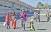  ?? BIPLOV BHUYAN/HT PHOTO ?? ■
Migrant worker Ranjit Rajput, 28, and his 4-year-old son walk back from Delhi to Uttar Pradesh in March.