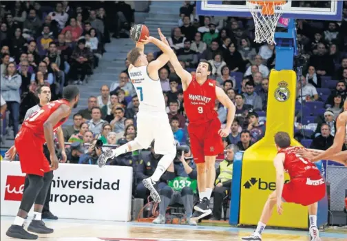  ??  ?? AL ARO. Luka Doncic supera la defensa del exmadridis­ta Blagota Sekulic. El base sumó en el tercer cuarto 12 puntos, 6 rebotes y 3 asistencia­s.