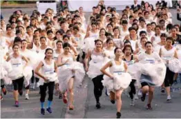  ?? REUTERSPIX ?? ... Brides-to-be participat­e in the ‘Running of the Brides’ race in a park in Bangkok on Saturday. Some 250 couples competed for wedding prizes which include wedding bands, a honeymoon at Phuket and a trip to the Maldives.