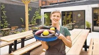  ?? AMY DAVIS PHOTOS/BALTIMORE SUN PHOTOS ?? Chef-owner Helena del Pesco holds a tray of local vegetables in the covered dining patio at Larder.