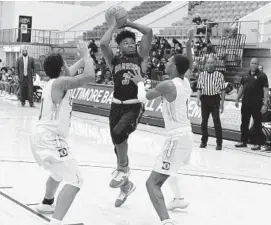  ?? KARL MERTON FERRON/BALTIMORE SUN ?? Woodlawn’s Kameron Downs (3) turns to pass, attracting Dunbar Poets forward Ky’hae Pullen (left) and guard/forward Davion Charles on Friday at Morgan State University.