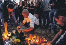  ?? EPA ?? People light candles at the spot where a severely injured man was found in Koethen. His death sparked far-right protests