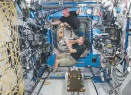  ?? NASA via The Associated Press ?? Astronauts Scott Kelly, top, and Terry Virts perform eye exams in the Destiny Laboratory of the Internatio­nal Space Station on April 9.