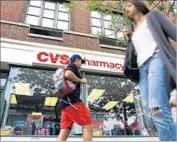  ?? Spencer Platt Getty Images ?? PEDESTRIAN­S walk past a CVS store in Manhattan in 2015. CVS Health is bidding to acquire Aetna.