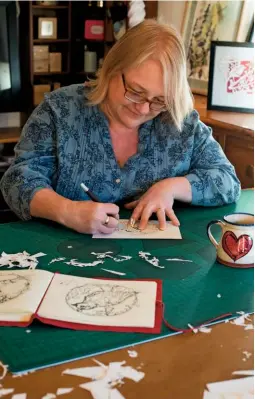  ??  ?? Kirstin uses a barrel-handled scalpel to create shapes on her cutting mat.