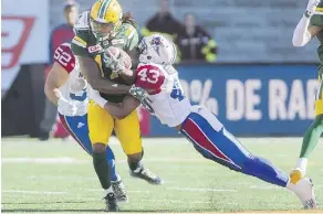  ?? THE CANADIAN PRESS ?? Edmonton Eskimos’ Troy Stoudermir­e, left, is tackled by Montreal Alouettes’ Dominique Termansen in Monday’s game.