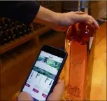  ??  ?? Après avoir téléchargé l’applicatio­n gratuite, il suffit de scanner l’étiquette à l’aide de son smartphone pour accéder aux fiches des vins.