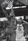  ?? ROSE BACA/TRIBUNE NEWS SERVICE ?? The Mavericks' Yogi Ferrell (11) scores against Jazz forward Derrick Favors (15) in Dallas on March 22.