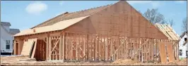  ??  ?? Above: Framing is nearly complete on a new single-family home in Emerald Oaks subdivisio­n off Old Dalton Road. Below: Shane Hudgins works on a garage door opener in Battle Farm subdivisio­n in Armuchee.