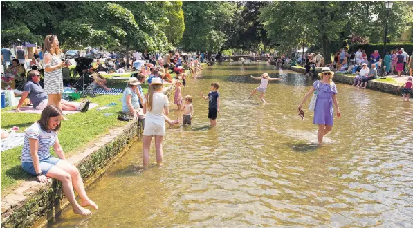  ??  ?? Cooling down in the River Windrush in the Cotswold village of Bourton-on-the-water yesterday. The Met Office has forecast that the 2011 record for June of 91.6F (33.1C) could be beaten this week