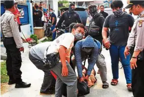  ?? — AFP ?? Under arrest: Indonesian special police members apprehendi­ng a suspected militant outside a home in Bekasi, West Java.