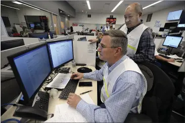  ?? PHOTOS BY JOEL ROSENBAUM — THE REPORTER ?? Pacific Gas and Electric safety officers, Jeff Ringwald and Myron Ko update the medical plan while participat­ing in an earthquake response drill Thursday in Vacaville. The plan keeps personnel informed of the status of the local hospital in the area. The goal of the drill is to train personnel and evaluate PG&E’s ability to implement a company-wide response to a catastroph­ic earthquake.