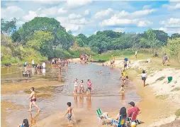  ?? ?? Numerosas personas, en especial niños, se refrescan en el arroyo Ñeembucú de la ciudad de Pilar.