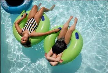  ?? DAVID CARSON — ST. LOUIS POST-DISPATCH VIA AP ?? Mya Jones, left, 12, and her cousin Alexis Carlen, 13, keep cool on a tubes floating around the Endless River at Raging Rivers Waterpark in Grafton, Ill., on Wednesday. An excessive heat warning has been issued for St. Louis through Saturday night.