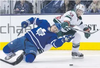  ??  CHRIS YOUNG/THE CANADIAN PRESS ?? The Leafs' Richard Panik battles for the puck with Minnesota Wild's Jordan Leopold on Monday night in Toronto. Toronto has been outscored 63-32 since mid-February.