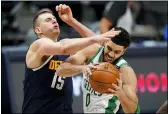  ?? DAVID ZALUBOWSKI — THE ASSOCIATED PRESS ?? The Celtics’ Jayson Tatum, right, pulls in a rebound as the Nuggets’s Nikola Jokic defends in the second half April 11 in Denver.