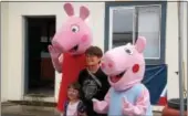  ?? CHARLES PRITCHARD - ONEIDA DAILY DISPATCH ?? A mother and child pose with Peppa and George Pig at the Make’N Bacon Festiva at Vets Field in Oneida on Saturday, Oct. 7, 2017.