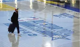  ?? MICHAEL CONROY / AP ?? Travelers at Indianapol­is Internatio­nal Airport make their way across a replica of the court that will be used for the NBA All-Star game, on Jan. 18.