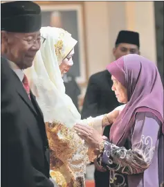  ??  ?? Tuanku Abdul Halim and Tuanku Hajah Haminah shake hands with palace staff at the end of reign of the 14th Yang di-Pertuan Agong and Raja Permaisuri Agong. — Bernama photo