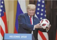  ?? AP PHOTO ?? OWN GOAL: President Trump accepts a soccer ball presented to him by Russian President Vladimir Putin.