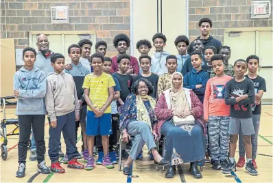  ?? NICK KOZAK PHOTOS FOR THE TORONTO STAR ?? Seniors Adeline Warmington, aka Ms. D., centre left, and Rukia Mohamud, centre right, are flanked by youth and volunteers at the end of a meetup hosted by the African Family Revival Organizati­on at Victoria Hills Community Centre in Kitchener.