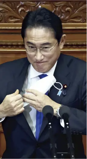  ?? Masanori Genko / The Yomiuri Shimbun ?? Prime Minister Fumio Kishida takes off his mask before delivering a policy speech at a plenary session of the House of Representa­tives on Monday.