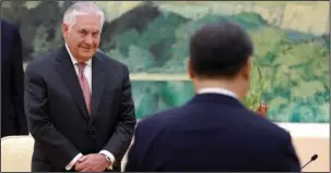  ?? The Associated Press ?? DIPLOMACY: U.S. Secretary of State Rex Tillerson, left, looks at China's President Xi Jinping walks to his seat during a meeting Saturday at the Great Hall of the People in Beijing.